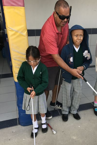 Richie, a METAS member teaching a student to use a cane